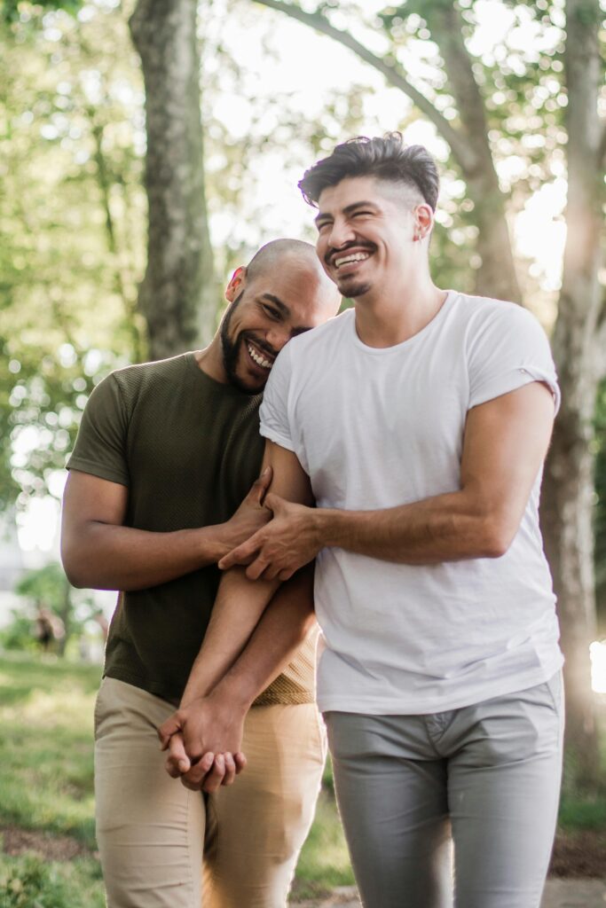 same sex male couple smiling and holding hands
