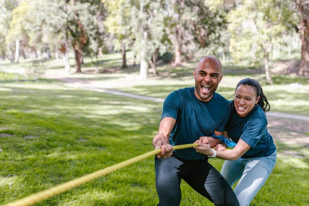 Couple on the same team, playing tug of war 